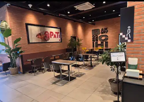시흥 꼬파티 카페 내부 붉은 벽돌 인테리어와 로고 벽면